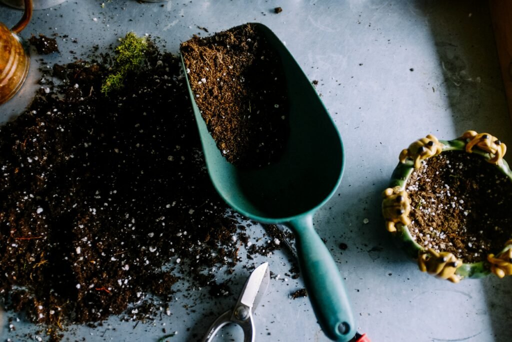 blue metal trowel filled with gardening soil